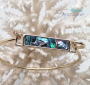 Round golden bracelet with an abalone mother-of-pearl stick